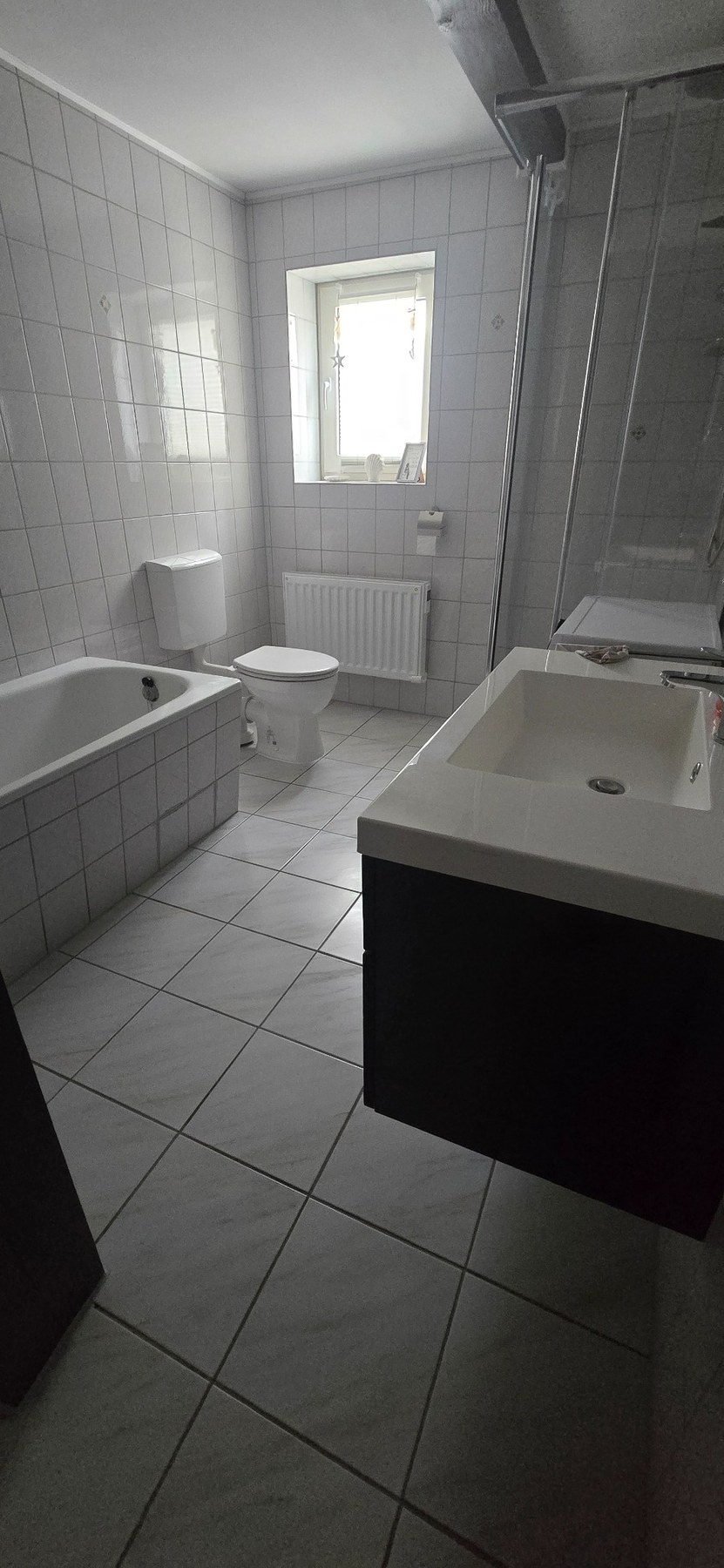 Badezimmer mit Badewanne, Dusche, Waschbecken und WC