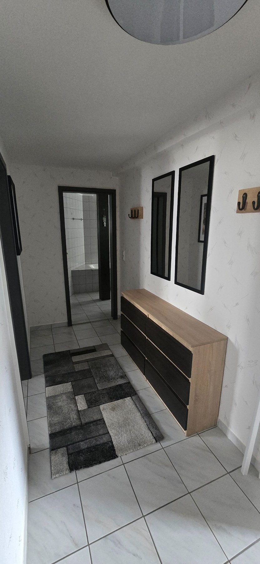 Heller Flur mit Kommode, Spiegeln und Garderobe